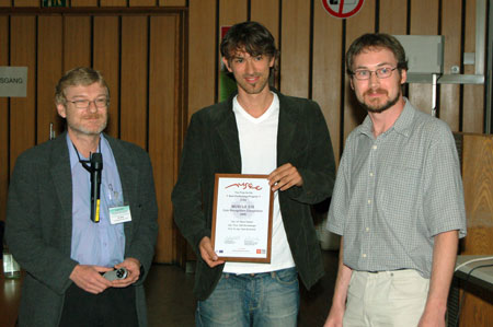 Marco Reisert (centre) receives the prize from competition organisers Michael Nölle (left) and Allan Hanbury (right).