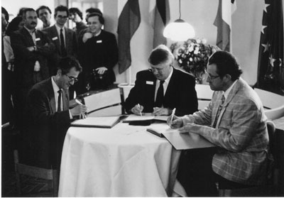 The birth of ERCIM: From left - Alain Bensoussan, INRIA, Friedrich Winkelhage, GMD (on behalf of Gerhard Seegmüller)  and Cor Baayen, CWI, sign the joint agreement on 13 April 1989. 